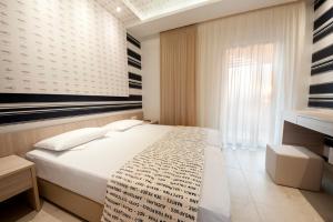 a bedroom with a white bed and a window at Louloudis Fresh-Adults Only in Skala Rachoniou