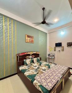 a bedroom with a bed and a ceiling fan at Next Home Stay in Nalkhera