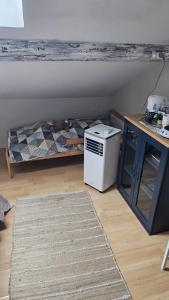 a room with a bed and a refrigerator and a table at L'étoile du matin in Terville
