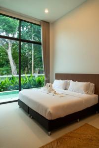 a bedroom with a large bed and a large window at Neon Villa in Ko Phangan +30 photos