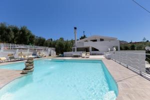 a large swimming pool with chairs and a house at La Duchessa e Il Contadino in Vieste