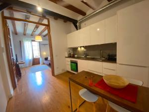 a kitchen with white cabinets and a wooden table at Calle Villarroel Barcelona 3-2 in Barcelona +7 photos