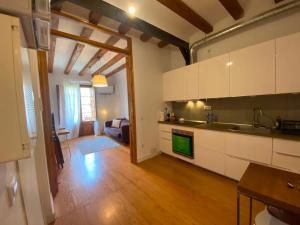a kitchen with white cabinets and a living room at Calle Villarroel Barcelona 3-2 in Barcelona