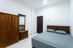 a bedroom with a bed and a dresser and a mirror at The Ivy Grove in Mahabage
