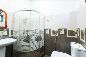 a bathroom with a shower and a toilet and a sink at The Ivy Grove in Mahabage