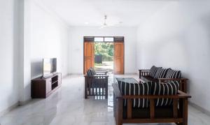 a living room with two chairs and a television at The Ivy Grove in Mahabage
