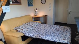 a couch with a blanket on it in a room at Le Relais des Ducs in Duras