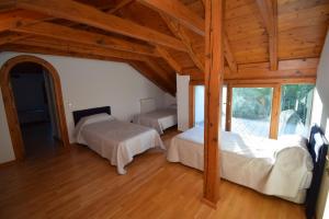 a bedroom with two beds in a room with wooden ceilings at La Casona Imperial 2 in Galapagar +83 photos