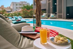 a table with a plate of food and a glass of orange juice at Zeus Piraeus Grand in Piraeus