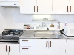 a kitchen with white cabinets and a sink at 헤이데이서울 in Seoul