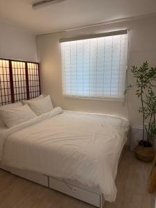 a bedroom with a white bed and a window at 헤이데이서울 in Seoul