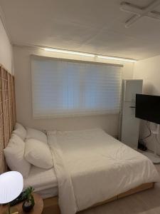 a white bed in a room with a window at 헤이데이서울 in Seoul +13 photos