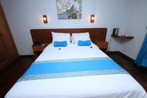 a bedroom with a bed with two blue pillows at Samana Hotel in Arequipa