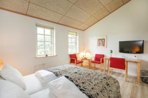 a bedroom with a bed and a table and chairs at Vilcon Hotel & Konferencegaard in Slagelse