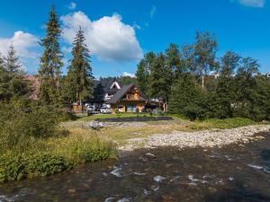 a house in the woods next to a river at Chocholowska Zohylina pokoje in Chochołów