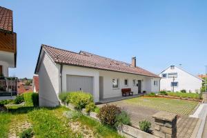 a small white house with a garage at Ferienwohnung am Alenberg in Münsingen