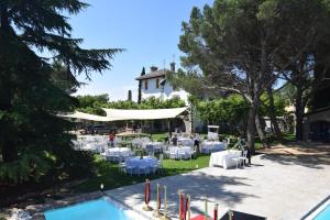 an outdoor event with white tables and chairs in front of a house at La Casona Imperial 2 in Galapagar