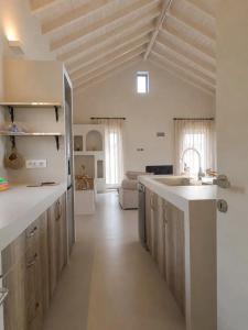 a large kitchen with a sink and a living room at Doto Villa with private pool in Agia Effimia
