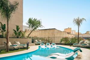 a swimming pool with lounge chairs and a resort at Zeus Piraeus Grand in Piraeus