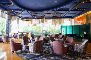 a restaurant with tables and chairs and a large window at Kempinski Hotel Shenzhen in Shenzhen