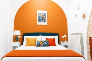 a bedroom with a bed with an orange wall at Casa Bottega in San Salvo