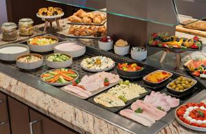 a buffet line with many different types of food at Leonardo Hotel München City Center in Munich +18 photos