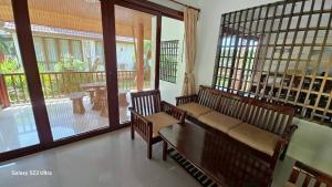 a living room with two benches and a balcony at Chaya village F shared pool jacuzzi in Phra Ae beach