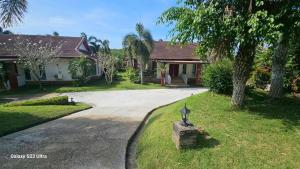 a house with a driveway with a statue in the grass at Chaya village F shared pool jacuzzi in Phra Ae beach