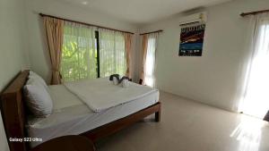 a bedroom with a bed with two towels on it at Chaya village F shared pool jacuzzi in Phra Ae beach +152 photos