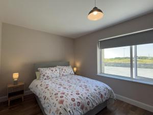 a bedroom with a bed and a large window at Ballyconneely Lodge in Ballyconneely