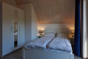 a bed in a bedroom with a wooden ceiling at Domki Beztroska Białogóra in Białogóra