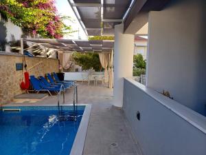 a swimming pool with blue chairs next to a building at Deluxe City in Chania
