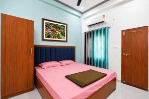 a bedroom with a pink bed and a picture on the wall at Vijay Villa in Faizābād