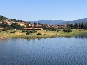 a large body of water with a town in the background at El Balcón de La Vega in Vinuesa