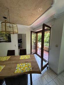 a dining room with a wooden table and a balcony at Apartment Grenzland in Herzogenrath