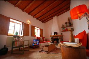 a living room with a couch and a fireplace at Casa Palheiro, Aldeia da Pedralva in Vila do Bispo