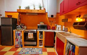 a kitchen with orange walls and a stove top oven at Casa Palheiro, Aldeia da Pedralva in Vila do Bispo +37 photos