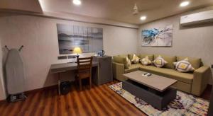 a living room with a couch and a desk at Sun City Resort in Calangute