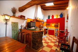 a kitchen with red and yellow cabinets and a counter at Casa Palheiro, Aldeia da Pedralva in Vila do Bispo
