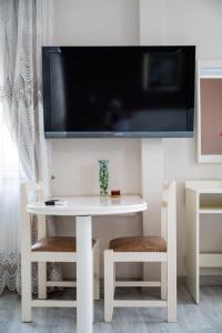 a white table with two chairs and a tv on the wall at DyHouse in Slatina +18 photos