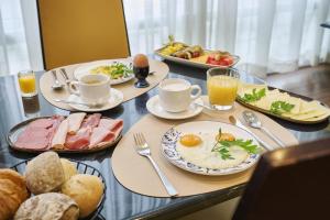Ein Tisch voller Teller mit Frühstücksspeisen und Getränken in der Unterkunft NH Leipzig Messe in Leipzig