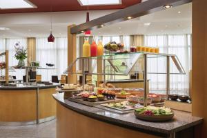 ein Buffet in einem Hotel mit Speisen an einer Theke in der Unterkunft NH Leipzig Messe in Leipzig