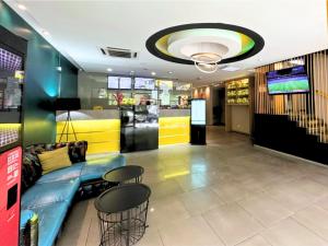 a lobby with a couch and stools in a room at Seeds Hotel Ampang Point in Kuala Lumpur