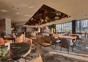 a hotel lobby with tables and chairs and a bar at Van der Valk Hotel Nuland - 's-Hertogenbosch in Nuland