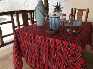 a table with a red and black plaid table cloth at Nanakizilodge in Mtendeni