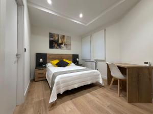a bedroom with a bed and a desk and a table at MTM Rooms in Santander +18 photos