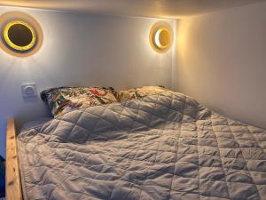 a bed in a bedroom with two lights on the wall at studio 25 in Dinard