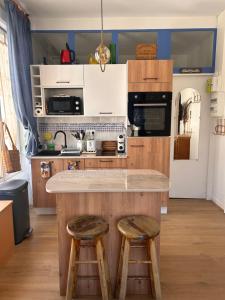 a kitchen with a counter and two stools in it at studio 25 in Dinard +14 photos