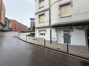 an empty street next to a white building at MTM Rooms in Santander