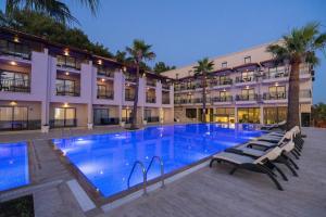 a large swimming pool in front of a building at Altamare Hotel in Kuşadası